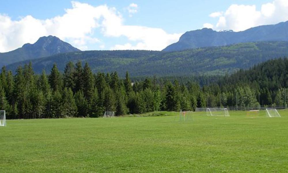 A soccer field with mountains in the background.