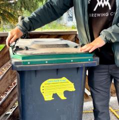 demonstration of how to lock a bear-resistant garbage bin